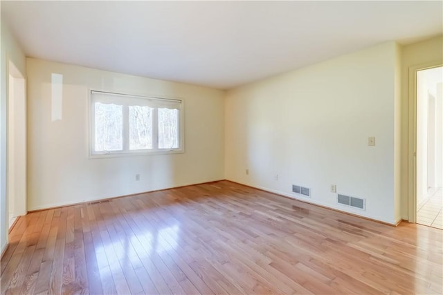 unfurnished room featuring light wood-style floors and visible vents