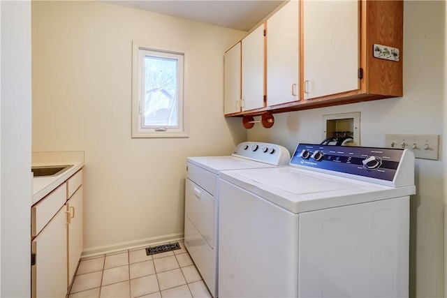 clothes washing area with baseboards, washer and clothes dryer, light tile patterned floors, cabinet space, and a sink