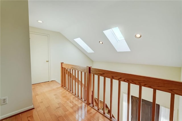 hallway with vaulted ceiling, light wood-style flooring, and recessed lighting