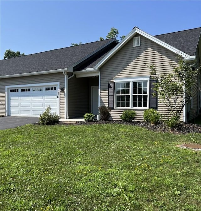 ranch-style home with a garage, driveway, a front lawn, and a shingled roof