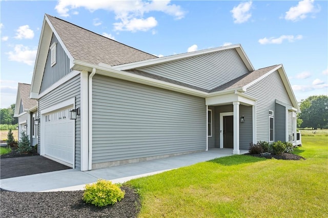 view of side of home with a lawn and a shingled roof