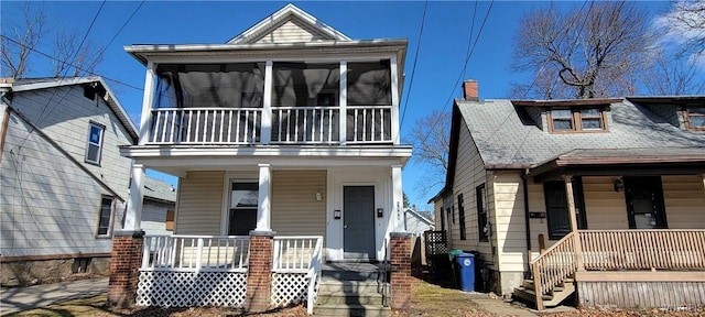 view of front facade featuring covered porch and a chimney