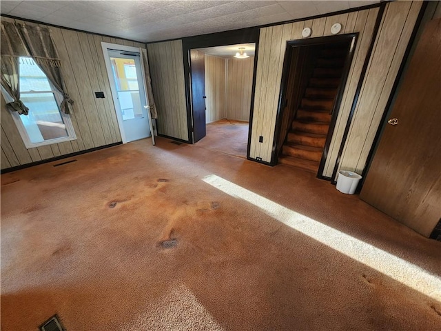 carpeted entrance foyer with visible vents and stairway