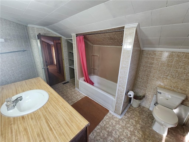 full bathroom featuring toilet, tile walls, lofted ceiling, and bathtub / shower combination