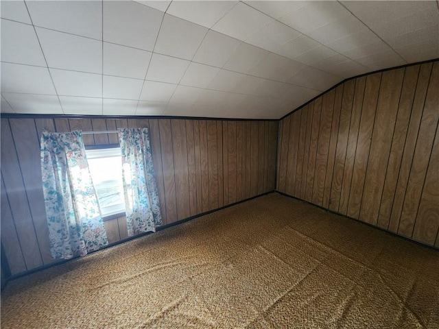 additional living space with lofted ceiling, wooden walls, and carpet flooring