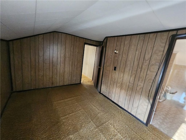 additional living space featuring lofted ceiling, wooden walls, and carpet floors