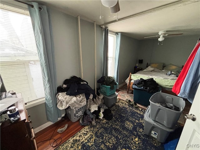 bedroom with ceiling fan, baseboards, and wood finished floors