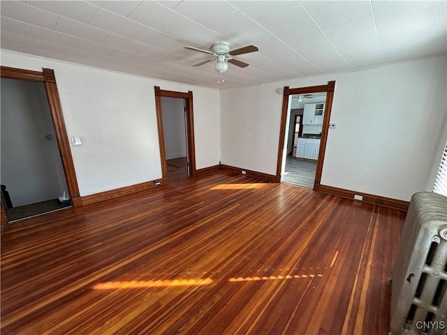 unfurnished living room with radiator, wood finished floors, baseboards, and ceiling fan