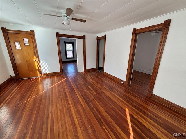 spare room with a ceiling fan, baseboards, and wood-type flooring