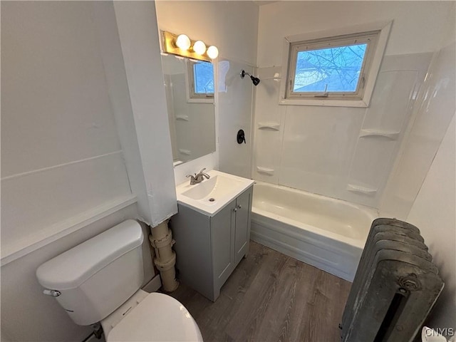 bathroom with shower / bathing tub combination, toilet, wood finished floors, and vanity