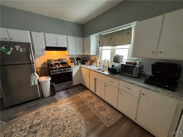 kitchen with under cabinet range hood, white cabinets, appliances with stainless steel finishes, and a sink