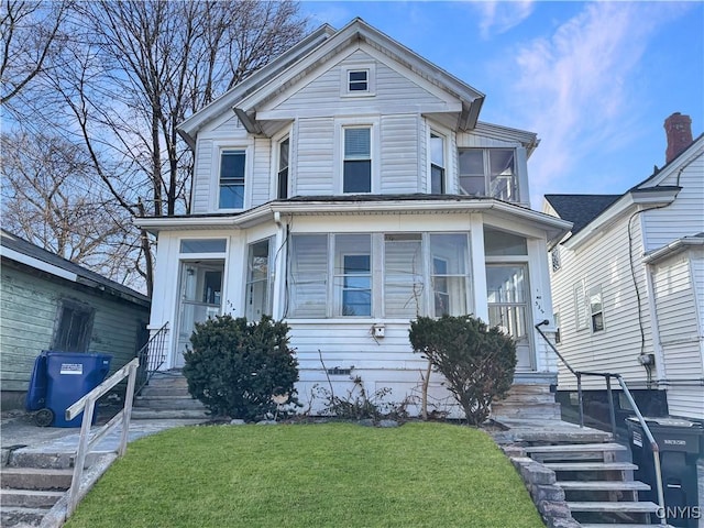 victorian-style house with a front yard and a sunroom