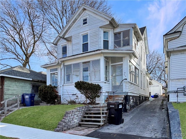 view of front facade featuring an outbuilding, a front yard, and entry steps