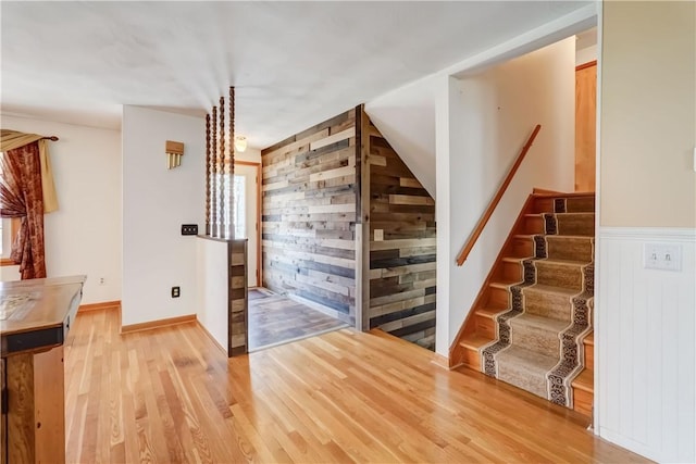 stairs featuring wooden walls and wood finished floors