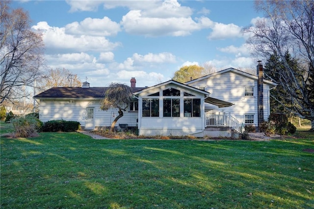 rear view of property with a yard, a chimney, and a sunroom