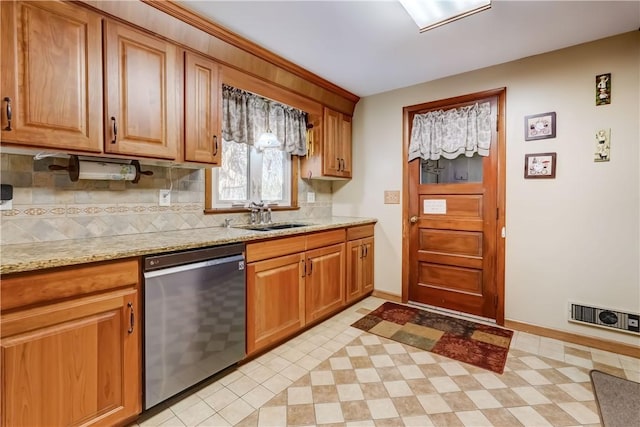 kitchen featuring visible vents, backsplash, light stone counters, stainless steel dishwasher, and a sink