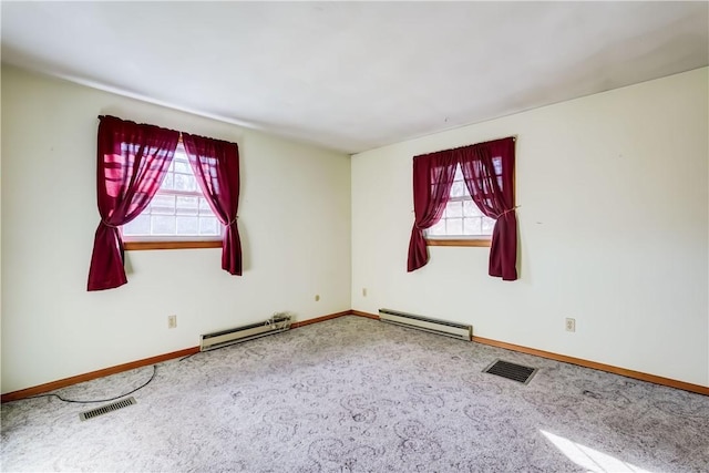 unfurnished room with a baseboard heating unit, carpet flooring, and visible vents