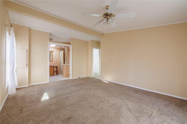 unfurnished room featuring visible vents, ornamental molding, a ceiling fan, carpet flooring, and baseboards