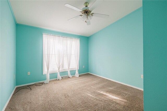 carpeted spare room featuring baseboards, ceiling fan, ornamental molding, and vaulted ceiling