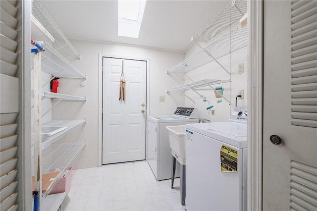 washroom with independent washer and dryer, a skylight, crown molding, light floors, and laundry area