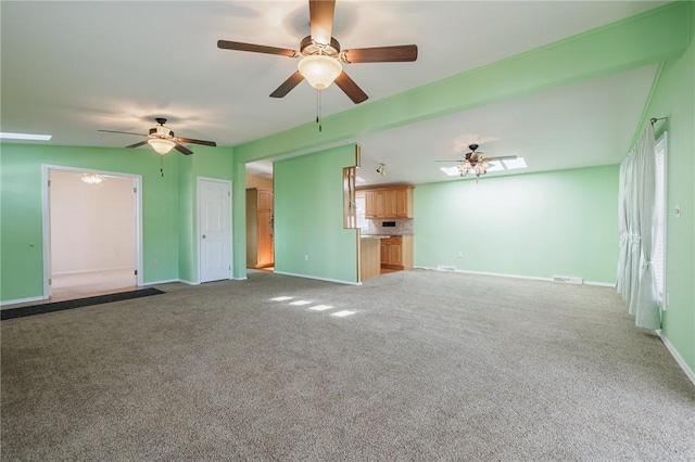 unfurnished living room with carpet, baseboards, and ceiling fan