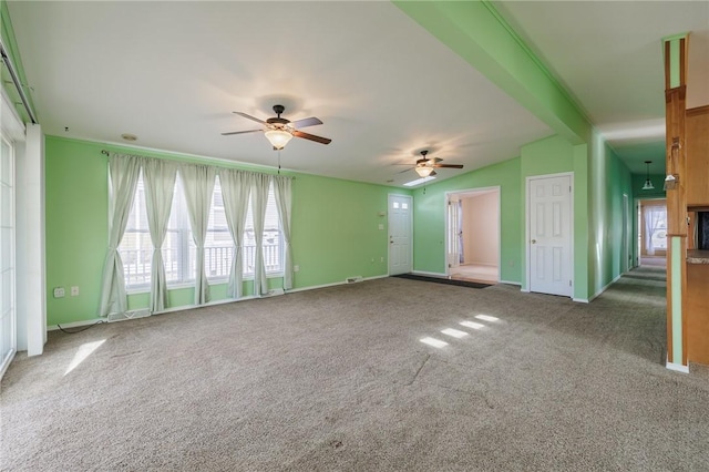 unfurnished living room featuring baseboards, ceiling fan, vaulted ceiling with beams, and carpet