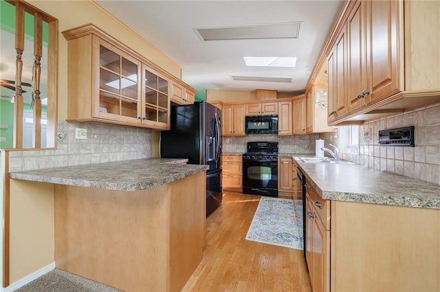 kitchen featuring decorative backsplash, black appliances, and glass insert cabinets