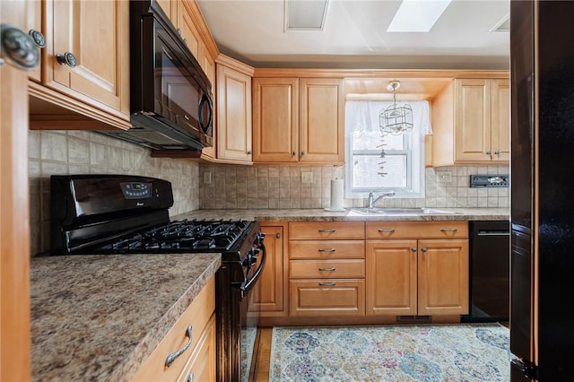 kitchen featuring light stone counters, backsplash, black appliances, and a sink