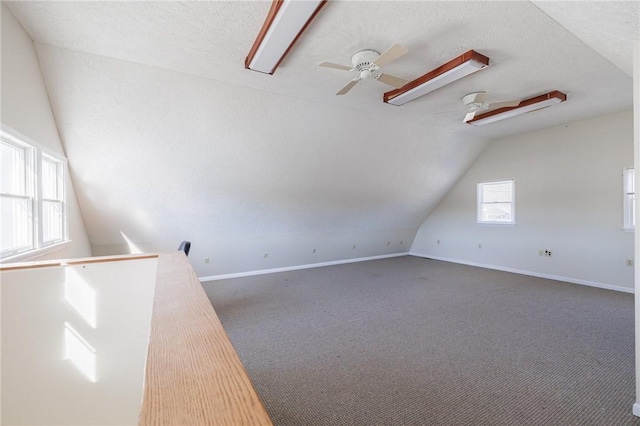 bonus room with baseboards, carpet flooring, a textured ceiling, and lofted ceiling