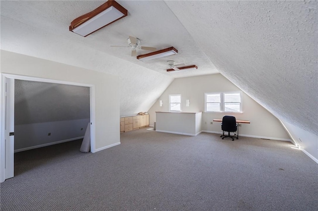 additional living space with ceiling fan, baseboards, carpet floors, vaulted ceiling, and a textured ceiling