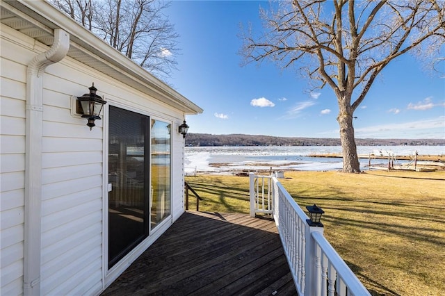 wooden terrace with a lawn and a water view