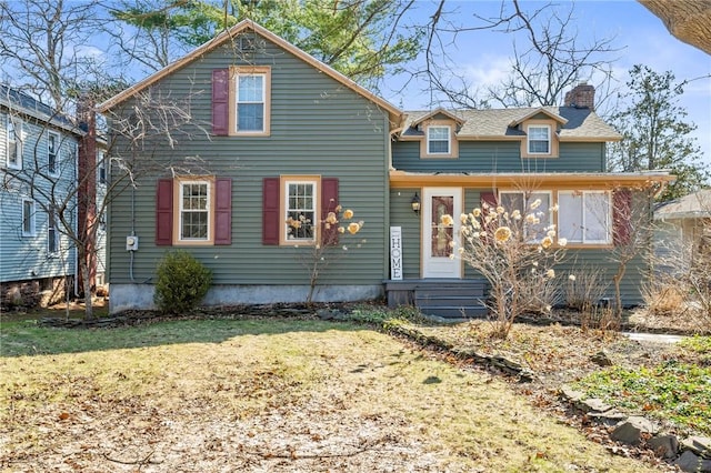 view of front of property with a front lawn, a chimney, and entry steps