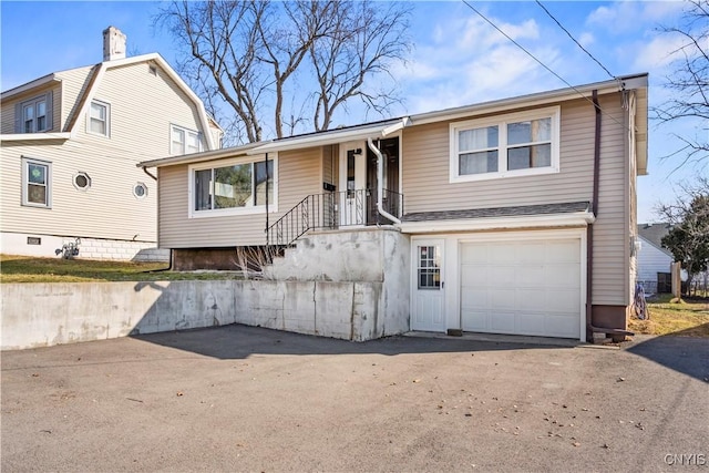 view of front facade featuring aphalt driveway and an attached garage