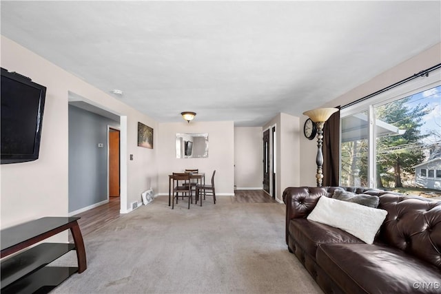 carpeted living room with visible vents and baseboards