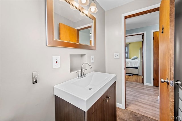 bathroom with vanity, baseboards, and wood finished floors