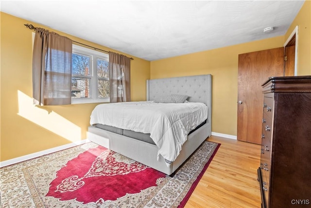 bedroom with light wood-type flooring and baseboards