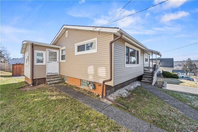 exterior space with fence, a lawn, and entry steps