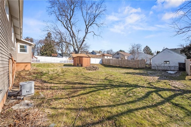 view of yard featuring an outbuilding, a storage unit, and a fenced backyard