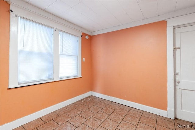 empty room featuring light tile patterned floors and baseboards