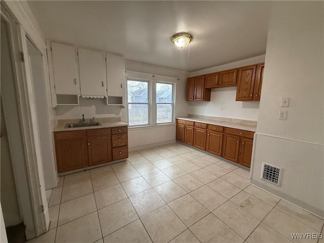 kitchen featuring brown cabinets, light countertops, and a sink