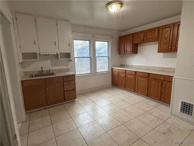 kitchen featuring a sink, brown cabinets, and light countertops