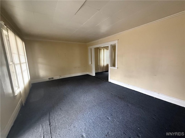 spare room featuring visible vents, baseboards, and ornamental molding