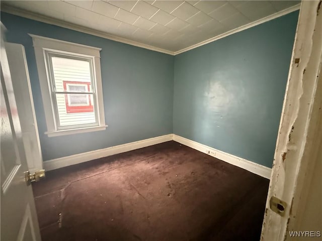 spare room featuring crown molding and baseboards