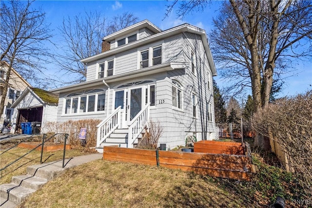 american foursquare style home featuring a front yard and fence