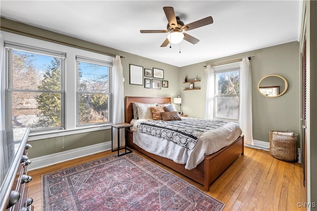 bedroom featuring a ceiling fan, baseboards, and light wood-type flooring