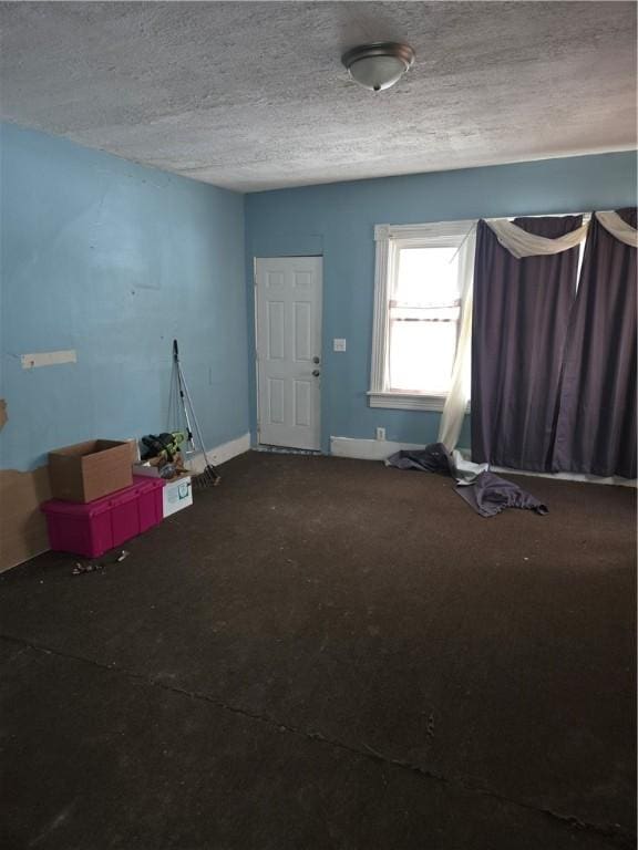 unfurnished room featuring baseboards and a textured ceiling