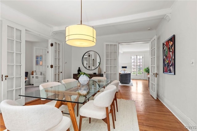 dining room with french doors, baseboards, and wood finished floors