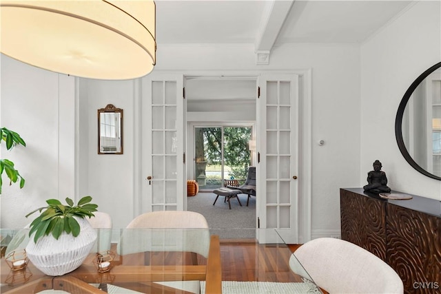 dining room featuring beamed ceiling, french doors, wood finished floors, and ornamental molding