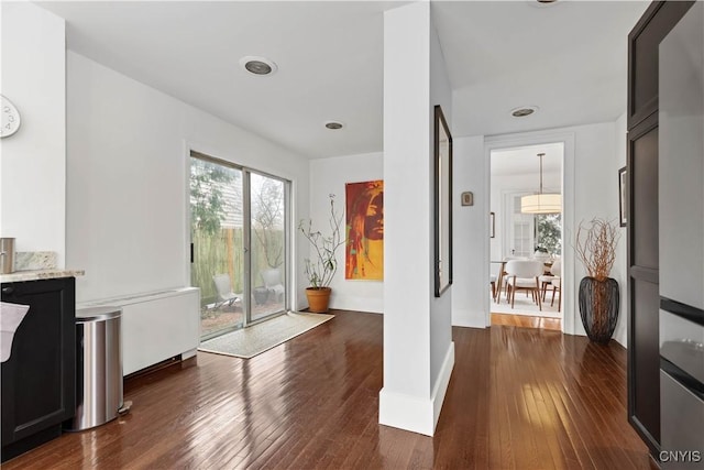 foyer entrance with a wealth of natural light, baseboards, and dark wood-type flooring