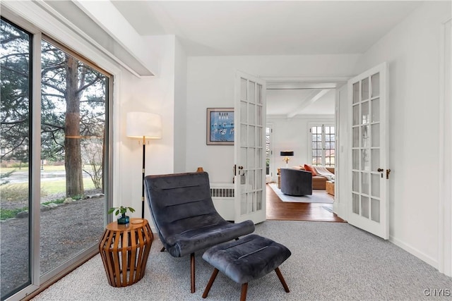 sitting room with french doors, radiator heating unit, and baseboards